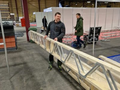 Darbinieks strādā pie jumta kopņu ražošanas iekārtas