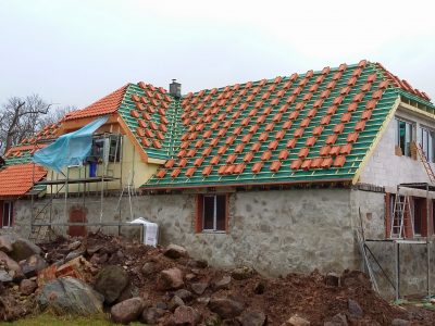 Darbinieki veic dakstiņa jumta uzstādīšanas darbus